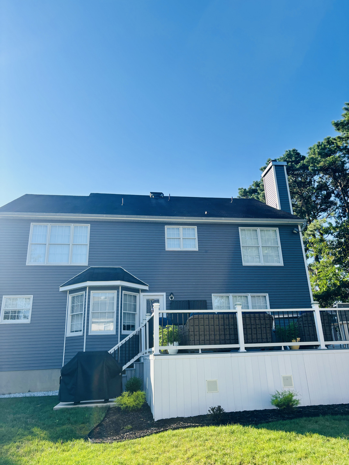 Finished roof replacement on the back of a gray shore home
